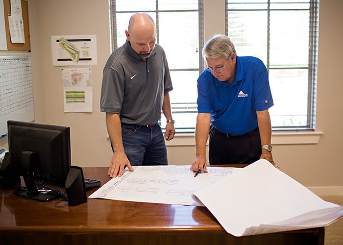 Sales Rep with Builder in Office Looking at Plans